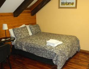 a hotel room with a bed and a chair at Pensión Panticosa in Panticosa
