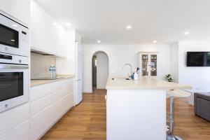 eine Küche mit weißen Schränken und einer weißen Arbeitsplatte in der Unterkunft EDEN RENTALS Luxury Heated-Pool Villa El Sauzal in El Sauzal