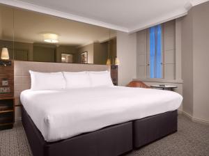a large white bed in a hotel room at Strand Palace in London