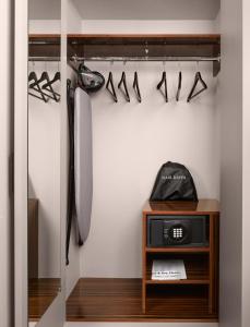 a walk in closet with a clock and shoes at Strand Palace in London