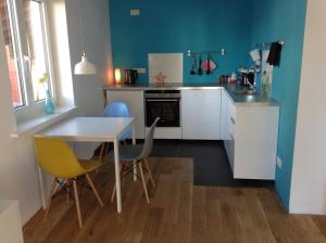 a kitchen with a table and chairs and a sink at Schlaf aus im Schwedenhaus in Eimeldingen