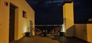 a balcony with chairs and a fence at night at Sea&Sunrise Village in Caniço
