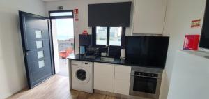 a kitchen with a washing machine and a washer at Sea&Sunrise Village in Caniço