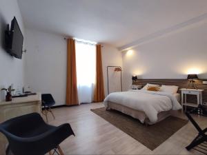 a bedroom with a bed and a tv and a chair at La Chambre Jaune - Chambre avec salle de bain in Argenton-sur-Creuse +6 photos