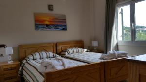 1 dormitorio con 2 camas y toallas. en Alipa Beach Apartment, en Paleokastritsa