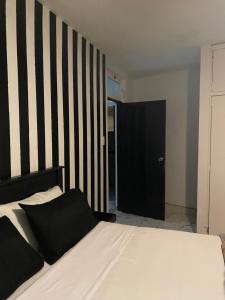 a bedroom with a bed with a black and white striped wall at Durban Beach Views at 10 South in Durban +18 photos