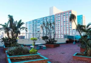 a large building with palm trees in a courtyard at Durban Beach Views at 10 South in Durban