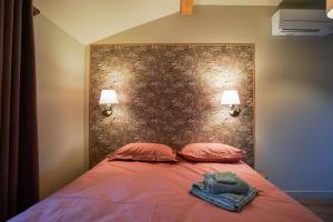 ein Schlafzimmer mit einem Bett mit zwei Kissen und zwei Lampen in der Unterkunft Le Petit Paradis de Pruzilly in Pruzilly