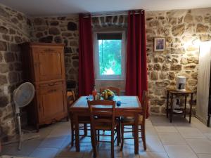 Les AssionsにあるGîtes Mas de la Musardièreのテーブルと椅子と窓のあるダイニングルーム