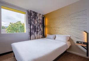 安锡B&B HOTEL Annecy Cran-Gevrier的卧室里有一张白色的大床和一扇窗户