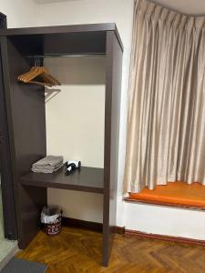 Una habitación con un estante y una ventana con una cortina. en Haven inn, en Johor Bahru