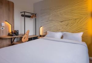 安锡B&B HOTEL Annecy Cran-Gevrier的卧室里有一张白色的床和一面木墙