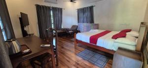 a bedroom with a bed and a desk and a desk at Vaiga Homes - Vembanadu Lakeview Retreat in Cochin