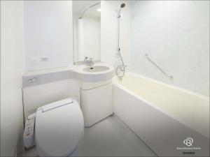 Un baño blanco con inodoro y lavabo. en Daiwa Roynet Hotel Osaka-Uehonmachi, en Osaka 35 fotos más