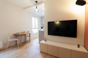 a living room with a large flat screen tv on a wall at Le Terracotta - T2 Design - Métro, RER & Jardin in Vincennes