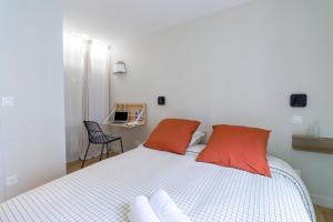 a bedroom with a bed with red pillows and a chair at Le Terracotta - T2 Design - Métro, RER & Jardin in Vincennes