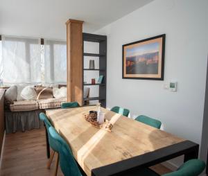ein Esszimmer mit einem Holztisch und grünen Stühlen in der Unterkunft El Alamo Sierra Nevada APTO NUEVO 2 habitaciones 2 baños en zona baja in Sierra Nevada
