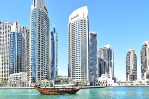 a boat in the water in front of a city at Moderne 1BR with a lovely marina view in Dubai