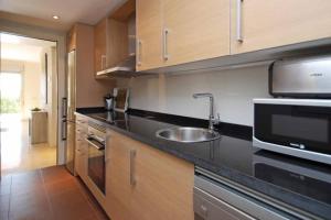 a kitchen with a sink and a microwave at Las Colinas Golf Club Residences Casa Encina 1 in Orihuela Costa
