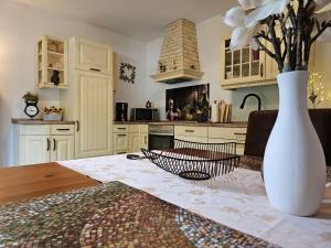a kitchen with a table and a vase with flowers at fewo-aller-auszeit in Hademstorf