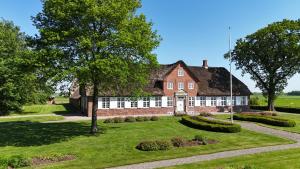 a large red brick house with a thatched roof at Bjerremark Hotel og Kursuscenter in Tønder