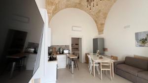 a kitchen and living room with a couch and a table at Casina Carducci Apartment in Nardò