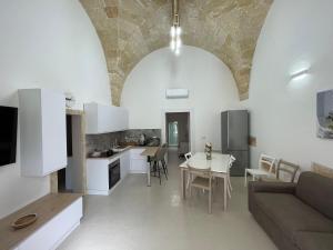 a kitchen and living room with a couch and a table at Casina Carducci Apartment in Nardò