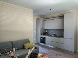 a living room with a couch and a kitchen at Alloggio Il Nocciolo in Cinto Caomaggiore