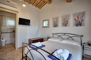 una camera con letto e TV e un bagno di Casa Andrea by PosarelliVillas a Siena