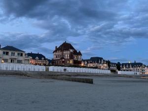 a house on the beach next to a white fence at Studio Le Picardy, déco rétro in Le Crotoy