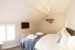 a bedroom with a bed with towels on it at Sandholme Cottage - Central location great for families in Filey