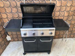 a black and white grill in front of a wall at Desconexión en la sierra casa con terraza y bbq in Miraflores de la Sierra