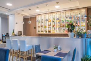 a restaurant with a bar with blue chairs at Hotel Urbi in Gdańsk