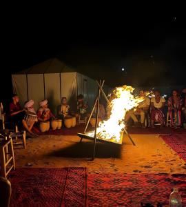 a fire show in front of a group of people at Exceptional Luxury Camp in Merzouga