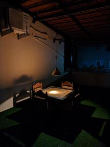 Habitación con mesa y sillas en una habitación oscura en Sakhey Homestay, en Ratnagiri