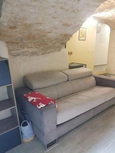 a couch in a living room with a stone wall at Petite maison de village charmante et authentique in Aniane +10 photos