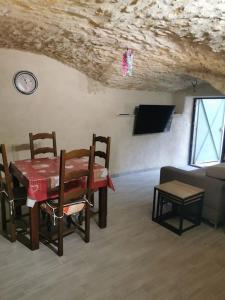 a dining room with a table and chairs and a couch at Petite maison de village charmante et authentique in Aniane