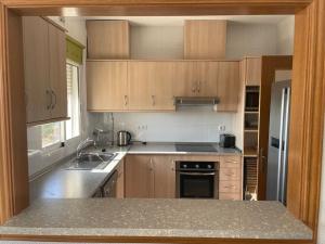 a kitchen with wooden cabinets and a counter top at Villa Del Sol in Alicante