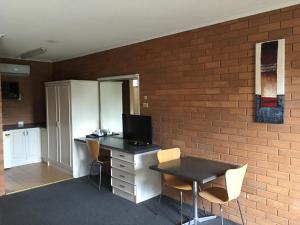 Cette chambre comprend un bureau avec un ordinateur et des chaises. dans l'établissement Essendon Motel, à Melbourne