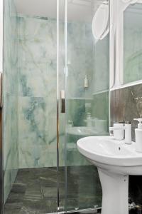 a bathroom with a sink and a glass shower at Unirii Zen in Iaşi +39 photos