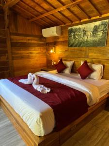 two beds in a room with wooden walls at Oemah Kangin Homestay in Amed +25 photos