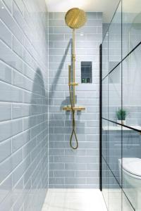 a bathroom with a shower with a sink and a toilet at Hideaway Cottage, Luxury, parking, study, EV in Bourton on the Water