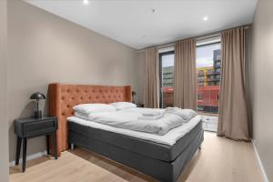 een slaapkamer met een bed en een groot raam bij Northstay - The Northview Retreat, Free Parking, Amazing Ocean Views in Tromsø