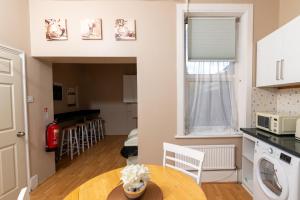 a kitchen and living room with a table and a window at Tranquil 3BR in Arnos Grove in New Southgate