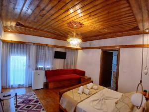 Cette chambre comprend un lit et un canapé. dans l'établissement Amaris Hotel, à Gjirokastër