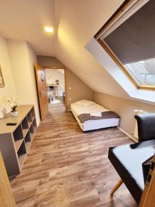 ヴォルフスブルクにあるMühlenberg Hofのベッドと窓が備わる屋根裏部屋