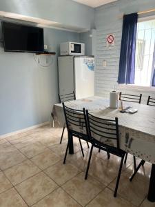 eine Küche mit Tisch und Stühlen und einem Kühlschrank in der Unterkunft Cabaña kaizen in San Rafael