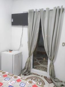 een gordijn in een kamer met een televisie en een vloer bij Navona beach - Casa de Praia com Piscina in Tutóia