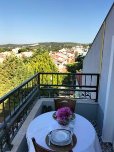 a table with plates and flowers on a balcony at The Rooftop Urla in Urla +4 photos