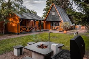 a backyard with a fire pit in front of a cabin at Tiszaparti Meseház in Tiszalök
